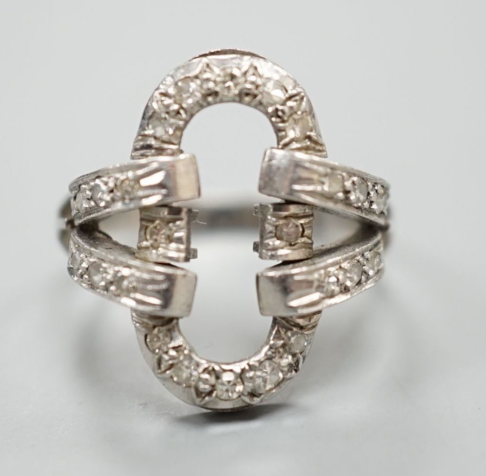 A white metal and diamond chip set open work oval dress ring, size M, gross 5.4 grams.